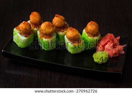 Japanese seafood. Rolls on a black plate