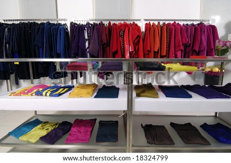 Designer clothes lined up in store - stock photo