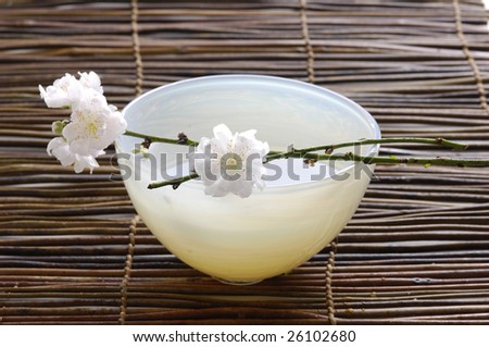 bowl of cherry blossoms on bamboo mat