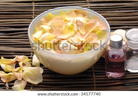 Body relax composition with bowl of rose petals with massage oil