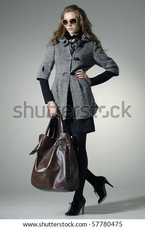 stock photo High fashion model with bag posing in the studio