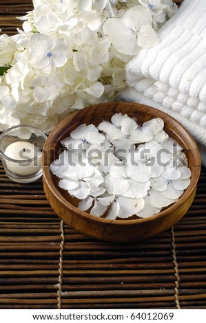 Spa treatments. bowl of hydrangea petals, white towel