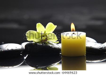 aromatherapy candle and zen stones with green orchid