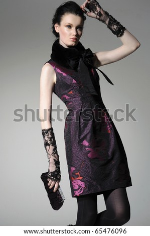 fashion model holding little purse in light background