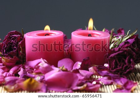 Two red candle and red roses petals