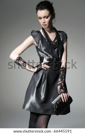 fashion model model holding little purse on gray background