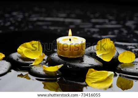 spa scene -aromatherapy candle and petals on zen stones