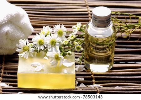 towel ,flower, lotion, with soap on bamboo mat