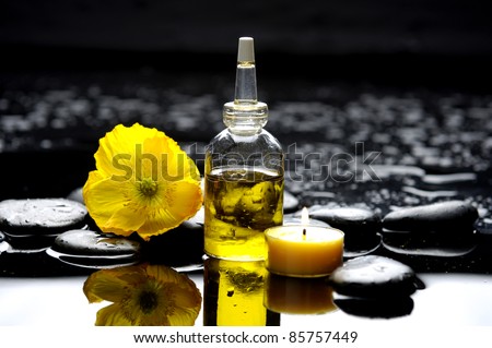 burning candle and macro of yellow flower on zen stones