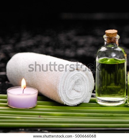 tranquil spa scene- towel with black stones with candle ,green plant