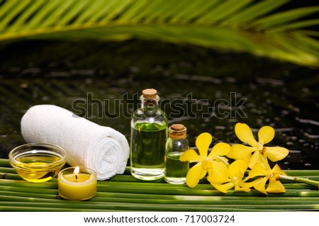 tranquil spa scene- yellow orchid with towel,candle with ,green plant,palm