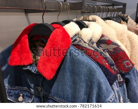 Jacket jeans ,sweater on the hanger in the store. Clothes hang on a shelf in a clothes store