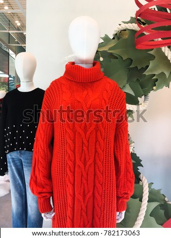 Two mannequins Dressed In Female red red Knitted wool sweaters .jeans In Store