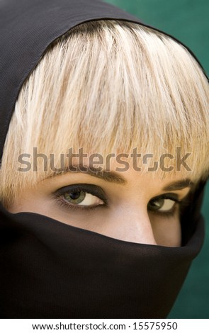 Closeup of beautiful arabic woman with green eyes wearing a black head cover