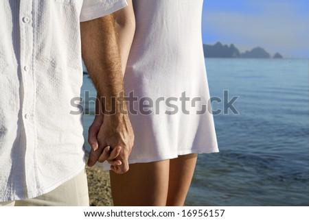 people walking on beach holding hands. on the each holding hands