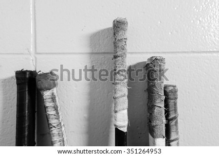 Black and white closeup shot of hockey sticks