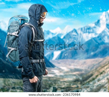 Portrait of man with backpack on the background of snow mounts