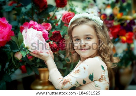 Cute little girl holding a flower. Smile, joy, tenderness.