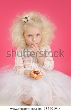 little girl in a tutu skirt with a cake on a pink background. Beauty, holiday, princess