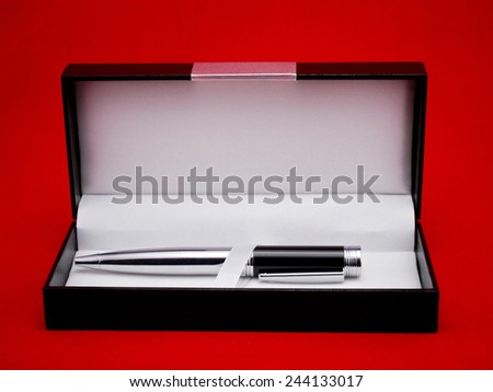 Metallic pen in a gift box against white background