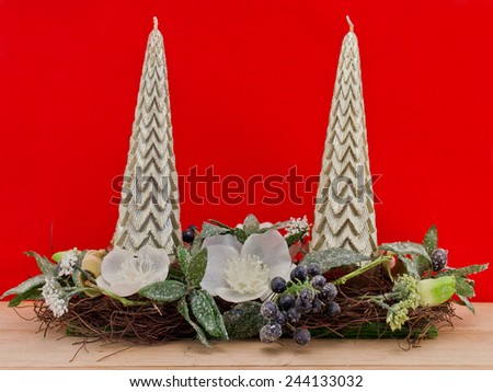 Pillars candle with  christmas decoration on the wooden floor against red background