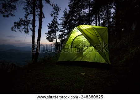 Adventures with green tent in the forest on the hills.