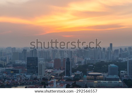 Singapore rooftop view of Marina Bay with urban skyscrapers at sunset.