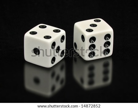 Two white dice with the lucky number seven showing.  The dice are on a solid black background with a soft reflection underneath them.  Good space for copy.
