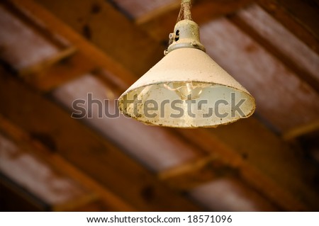 Antique Metal Light Hanging From Old Wooden Barn Ceiling