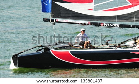 SINGAPORE - APRIL 13: Alinghi skipper steering the boat at the Extreme Sailing Series race at Marina Bay Reservoir April 13, 2013 in Singapore