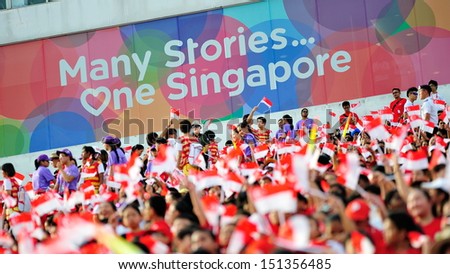 SINGAPORE - JULY 20: Spectators waving Singapore flags during National Day Parade (NDP) Rehearsal 2013 on July 20, 2013 in Singapore