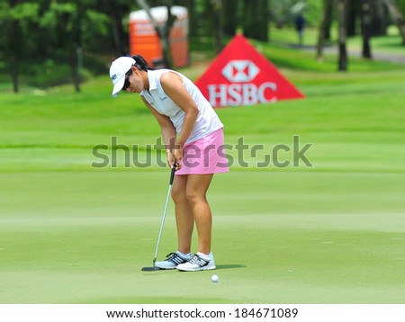 SINGAPORE - MARCH 2: American player Candie Kung putting at the green during HSBC Women\'s Champions at Sentosa Golf Club Serapong Course March 2, 2014 in Singapore
