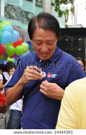 SINGAPORE - JANUARY 10: Minister Teo Chee Hean putting on Youth Olympic Games logo pin on his shirt during the logo launch ceremony January 10, 2009 in Singapore