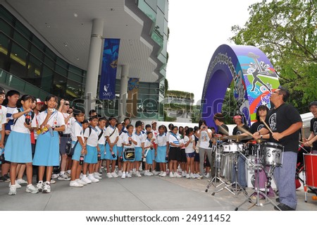 SINGAPORE - JANUARY 10: School children watching Voodoo band performance prior to the Singapore 2010 Youth Olympic Games logo launch ceremony January 10, 2009 in Singapore