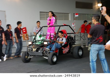 SINGAPORE - AUGUST 09: Event host Jean Danker riding a buggy during Singapore National Day Parade August 09, 2008 in Singapore