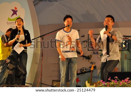 SINGAPORE - JANUARY 10: Event hosts Daniel Ong and Ivee Tan with singer Jack Ho from EIC band during concert after Singapore Youth Olympic Games logo launch January 10, 2009 in Singapore