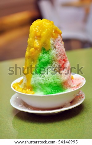 Bowl of ice kacang (red bean) dessert with mango and corn topping