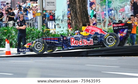 SINGAPORE - APRIL 24: David Coulthard drives Red Bull Racing F1 car RB6 down the ramp to perform stunts during Red Bull Speed Street Singapore on April 24, 2011 in Singapore.