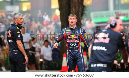 SINGAPORE - APRIL 24: David Coulthard faces the audience after performing stunts in Red Bull Racing F1 car RB6 during Red Bull Speed Street Singapore on April 24, 2011 in Singapore.