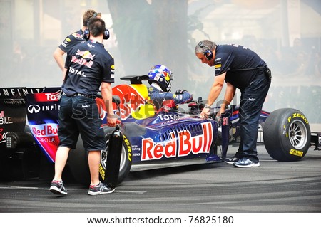 SINGAPORE - APRIL 24: Red Bull Racing pit crews cooling the F1 RB6 car after David Coulthard performed donuts during Red Bull Speed Street Singapore on April 24, 2011 in Singapore.