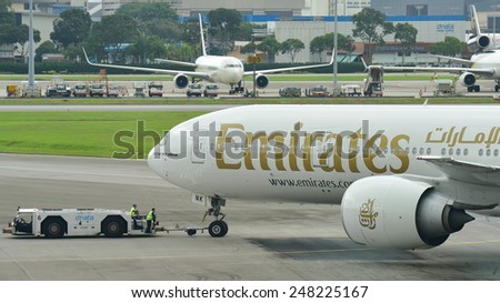 SINGAPORE - JANUARY 10: Emirates Boeing 777-300ER being pushed back at Changi Airport on January 10, 2015 in Singapore