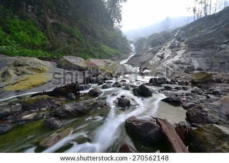 River water green with volcanic sulphur content flowing in East Java, Indonesia