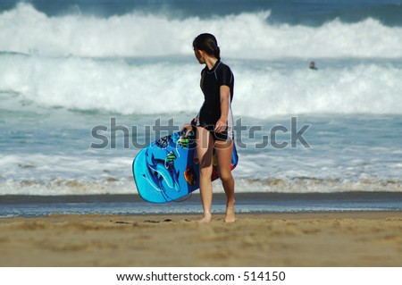 young girl on beach with her body board