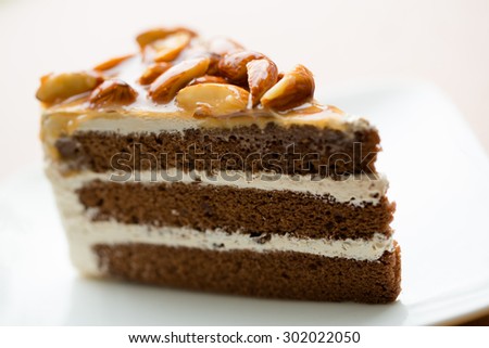 A Slice of Coffee Almond Cake on white plate, blurry background