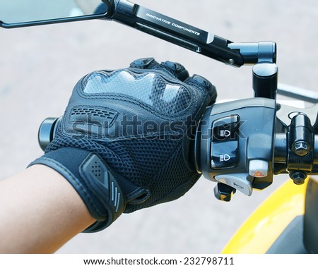 Human hand in a Motorcycle Racing Gloves holds a motorcycle throttle control .Hand protection from accidents.