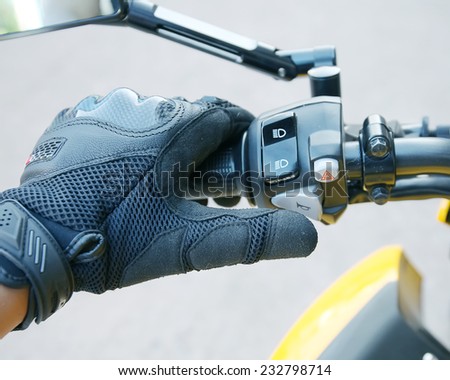 Human hand in a Motorcycle Racing Gloves Press the horn button .Hand protection from accidents.