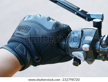 Human hand in a Motorcycle Racing Gloves holds a motorcycle throttle control .Hand protection from accidents.