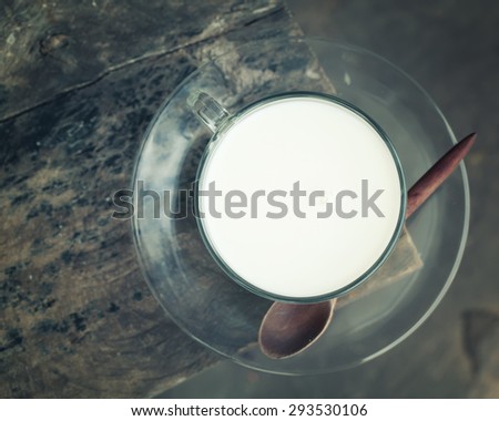 Hot milk in a glass on  wooden background. close up overhead view,Vintage Style.