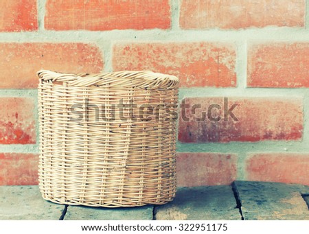 Wicker basket at the brick wall on wooden floor.interior decor -vintage filter effect.