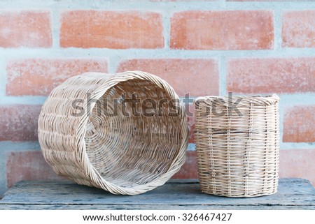 Wicker basket at the brick wall on wooden floor.interior decor.